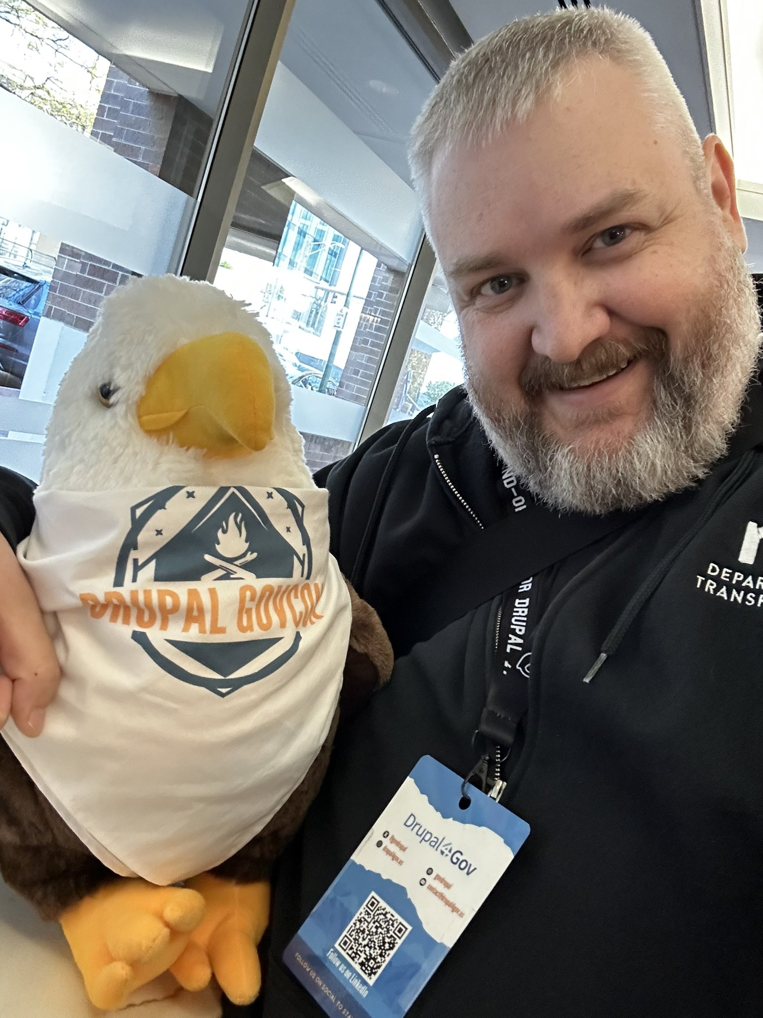 Mike posing with the Sammy the Eagle plush toy at Drupal GovCon